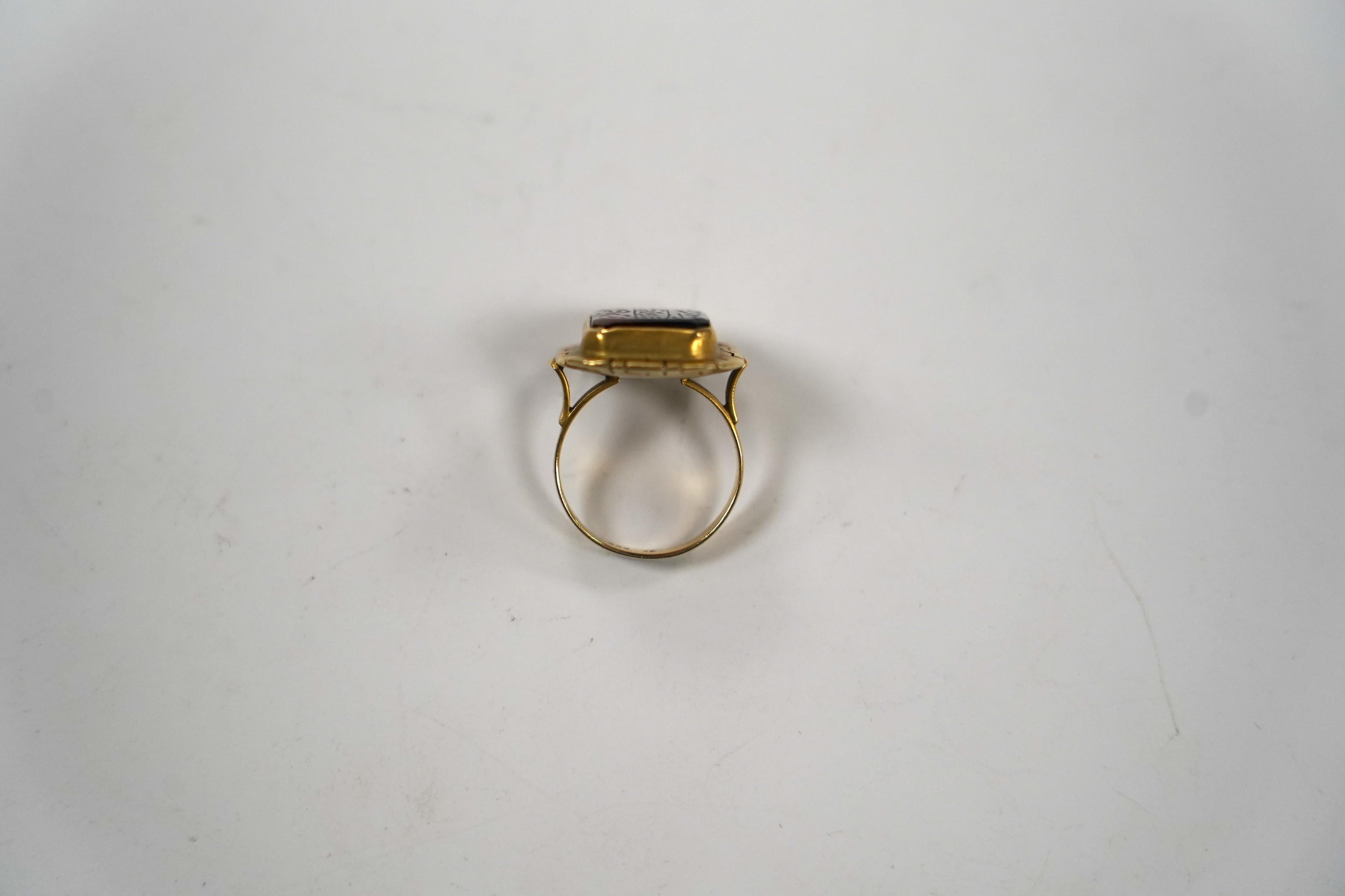 A 14k and carnelian set ring, with pierced border and stone inscribed with Islamic script, size O, gross weight 5.8 grams, in an Ilia Lalalounis box.